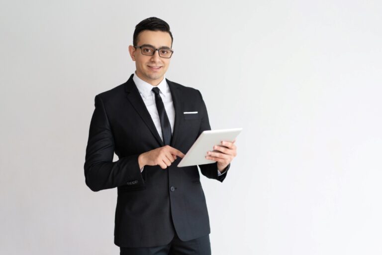cheerful-young-businessman-checking-email-tablet-looking-camera